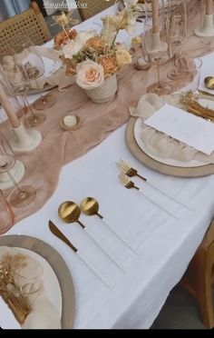 the table is set with gold and white place settings