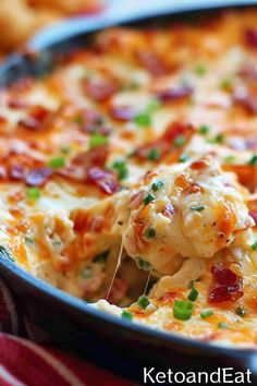 a cheesy casserole with bacon and green onions in a blue dish