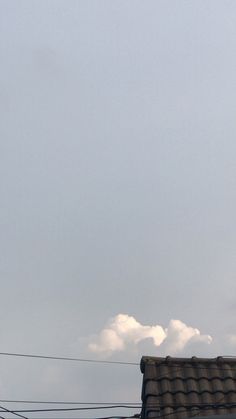 an airplane is flying high in the sky with power lines and wires below it on a cloudy day