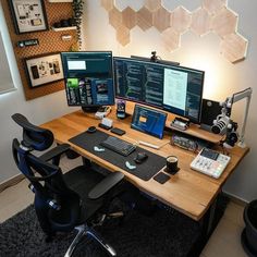 a desk with three computer monitors and two laptops on it, along with other office equipment