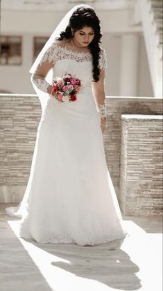 a woman in a wedding dress is standing outside