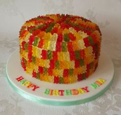 a birthday cake made out of gummy bears on top of a white tablecloth