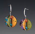 two pairs of earrings with colorful designs hanging from the ear hooks on a gray background