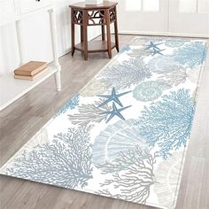 a white and blue area rug with starfishs, corals and seashells on it