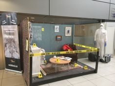 an office cubicle is taped up with yellow tape and some mannequins are in the background