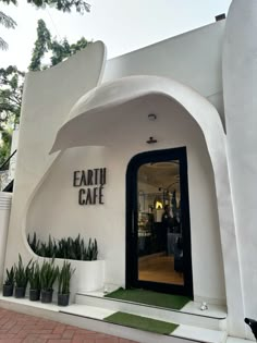 the entrance to earth cafe with plants and potted plants in pots on either side