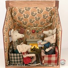 two stuffed mice in a wooden box with christmas decorations on the top and below them