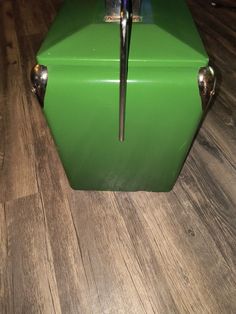 a green refrigerator sitting on top of a wooden floor