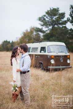 a couple kissing in front of an old vw van