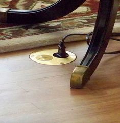 a close up of a floor lamp on a wooden floor with a rug in the background