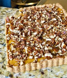 a pie with nuts on top sitting on a counter