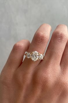 a woman's hand with a three stone ring on top of her left hand