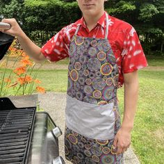 a man in an apron is cooking on the grill with his hands out to the camera