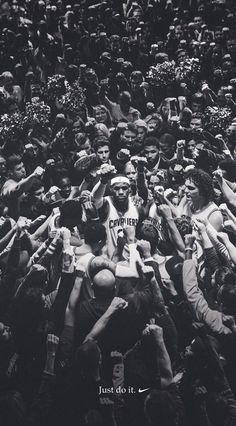 a group of people standing around each other in front of a crowd with their hands up