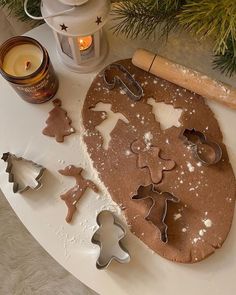 cookie cutters and cookies on a table next to a christmas tree ornament