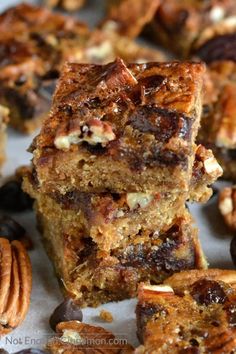 several pieces of pecan bars stacked on top of each other with nuts around them