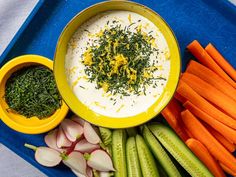 carrots, celery, cucumbers and other vegetables on a blue tray