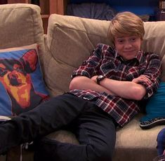 a boy sitting on a couch with his arms crossed