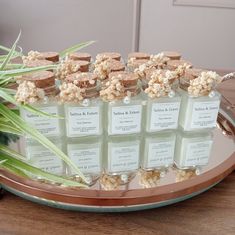 there are many small jars on the table with some flowers in them and one is filled with soap