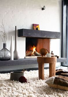 a living room filled with furniture and a fire place in the middle of the room