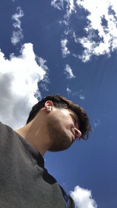 a man is looking up at the sky with his earbuds in front of him