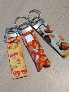 three pairs of scissors are sitting next to each other on a wooden table with mushrooms and mushrooms