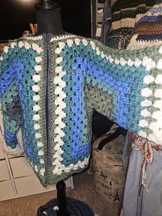 a blue and white crocheted sweater sitting on top of a mannequin