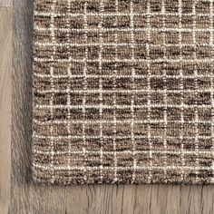 a brown and white rug on top of a wooden floor