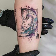 a person with a tattoo on their arm is holding up a piece of art that looks like an object