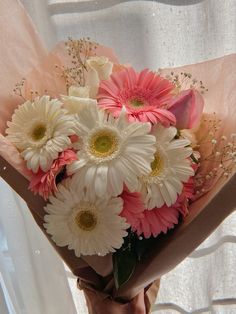 a woman holding a bouquet of white and pink flowers