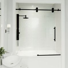 a bathroom with a tub, sink and shower curtain in black and white color scheme