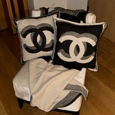 three black and white pillows sitting on top of a chair