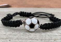 a black and white bracelet with a soccer ball on it