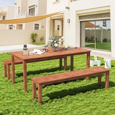 a wooden table and benches in the grass