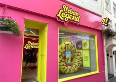 a pink store front with a giant donut in the window