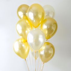 a bunch of yellow and white balloons in the air