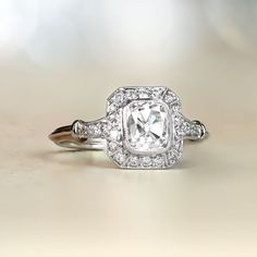 This stunning platinum halo-style engagement ring features a GIA-certified 1.10-carat antique cushion cut diamond with G color and SI1 clarity. Decorating the diamond is a diamond halo as well as more diamonds along the shoulders. The platinum ring features a lovely under-gallery.   ✦DIAMOND SPECIFICATIONS:   GIA- Certification: GIA- Certifiacte   Diamond Weight: 1.10-Carats   Diamond Color: G Color   Diamond Clarity: SI1 Clarity   Diamond-Cut: Cushion Cut ✦ ENGAGEMENT RING SPECIFICATIONS: Ring Classic Gia Certified Square Cut Diamond Ring, Classic Square Cut Gia Certified Diamond Ring, Classic Gia Certified Diamond White Halo Ring, Vintage White Diamond Ring With Halo Setting, Classic Gia Certified Cushion Cut Diamond Ring, Cushion Cut Halo Diamond Ring In Diamond White, Timeless Cushion Cut Gia Certified Diamond Ring, Heirloom Cushion Cut Diamond White Ring, White Halo Ring With Asscher Cut Center Stone