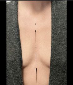 the back of a woman's chest with an arrow tattoo on it, as well as her breast