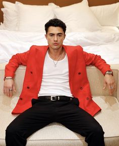 a man in a red jacket sitting on a couch