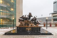 a statue in front of a building with snow on the ground