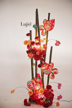 an arrangement of flowers and butterflies on sticks