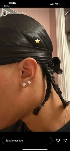 a woman with braids in her hair wearing a black leather headband and gold star earring