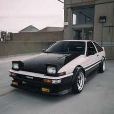 a black and white car parked in front of a building