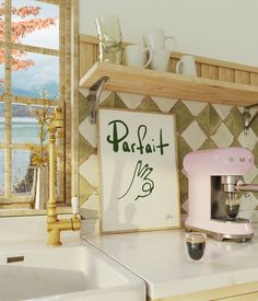 a pink coffee maker sitting on top of a kitchen counter next to a white sink