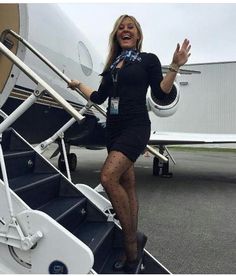 a woman in tights and stockings walking up the stairs to an airplane with her hand out