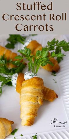 stuffed crescent roll carrots on a white plate with parsley sprigs in the background