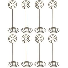 eight metal lollipops with spiral designs on them, hanging from the ceiling