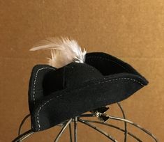 "Handcrafted from black cotton flannel; embellished with painted wood pirate emblem and white feather. This mini hat is a great way to add quick, festive charm or create an instant costume! No worry about \"hat hair\" once the hat is removed. Select either the clip on (alligator clip) or the ribbon casing sewn to the underside of the hat to slide in your metal or plastic headband (headband is not included). Be ready each year for International Talk Like a Pirate Day - September 19! Sized just ri Pirate-themed Black Costume Accessories, Black Pirate Costume Accessories For Themed Events, Adjustable Pirate Top Hat For Costume, Adjustable Pirate Style Top Hat For Costume, Black Pirate Mini Hats For Costume, Talk Like A Pirate Day, Talk Like A Pirate, Pirate Hat, Mini Hat