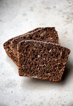 two slices of brown bread sitting on top of a white countertop next to each other