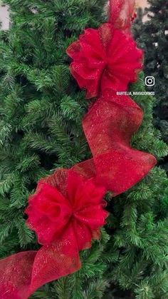 two red bows on top of a christmas tree